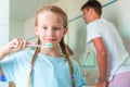 Happy girl and dad brushing her teeth in the bathroom toothbrushes Royalty Free Stock Photo