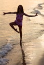 Happy girl dancing on the beach at the sunset time Royalty Free Stock Photo