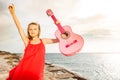 Happy girl dancing and playing guitar by the sea Royalty Free Stock Photo