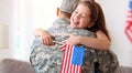 Happy girl daughter with american flag hugging father came back from US army Royalty Free Stock Photo