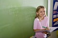 Happy girl doing math on blackboard in class Royalty Free Stock Photo