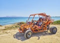 A happy girl driving a Buggy on a beach dune. Kos island. South