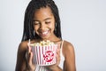 Happy girl eating popcorn over gray background