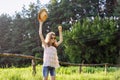 Happy girl enjoying summer vacation, kid in nature on green meadow playing with hat Royalty Free Stock Photo