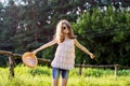 Happy girl enjoying summer vacation, kid in nature on green meadow playing with hat Royalty Free Stock Photo