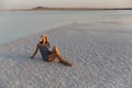 Happy girl enjoying the sunset in wide-brimmed straw hat , sit on salt