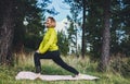 Happy girl exercising outdoors in green park, activity with stretch legs. Young fitness woman doing stretching exercises training Royalty Free Stock Photo