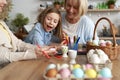 Girl with family plays with the decoration of Easter eggs