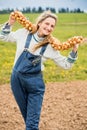 happy girl farmer in a field in denim overalls holds a bunch of onions. Planting bulbs in the ground in the garden.The