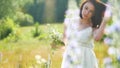 Happy girl in a field with flowers in nature. girl in a field smiling woman holding a bouquet of flowers outdoor Royalty Free Stock Photo