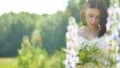 Happy girl in a field with flowers in nature. girl in a field smiling woman holding a outdoor bouquet of flowers Royalty Free Stock Photo