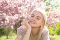 Happy girl with flowers in grass. Cute face of smiling young woman on spring. Dream woman.