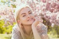 Happy girl with flowers in grass. Cute face of smiling young woman on spring. Dream woman.