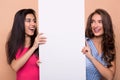 Happy girl friends holding blank advertisement board Royalty Free Stock Photo