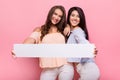 Happy girl friends holding blank advertisement board Royalty Free Stock Photo