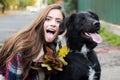 Happy girl gets lovely dog, plays and embraces. Humans and dogs. Girl with tongue embracing puppy dog outdoor. Royalty Free Stock Photo