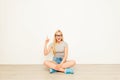 Happy girl in glasses with great idea sitting on floor with crossed legs Royalty Free Stock Photo