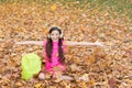 Happy girl in good mood throw up autumn leaves, school time