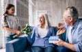 The happy girl and grandfather giving flowers and a gift to a grandmother. Royalty Free Stock Photo