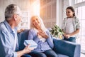 The happy girl and grandfather giving flowers and a gift to a grandmother. Royalty Free Stock Photo