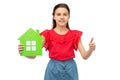 happy girl with green house icon showing thumbs up Royalty Free Stock Photo