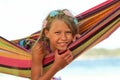 Happy girl on a hammock near the sea