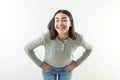 Happy girl with hands on her hips. She feels happy and has a nice smile. Green sweater and jeans Royalty Free Stock Photo