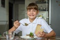 Happy girl happily eats the second dish and looks into the frame with a cute smile