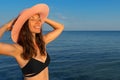 Happy girl in hat sunbathes in water at sea beach. Summer vacation concept Royalty Free Stock Photo