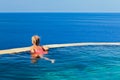 Girl at edge of infinity swimming pool with sea view Royalty Free Stock Photo