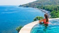 Woman at edge of infinity swimming pool with sea view Royalty Free Stock Photo