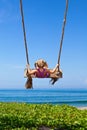 Happy girl have fun swinging high on sea beach Royalty Free Stock Photo