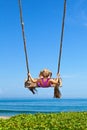 Happy girl have fun swinging high on sea beach Royalty Free Stock Photo