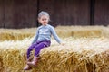 Happy girl having fun with hay on a farm Royalty Free Stock Photo