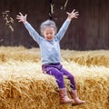 Happy girl having fun with hay on a farm Royalty Free Stock Photo