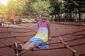 Happy girl having a rest on the playground in local park during her travelling Royalty Free Stock Photo