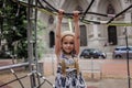 Happy girl having a rest on the playground in local park during her travelling Royalty Free Stock Photo