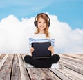 Happy girl with headphones showing tablet pc