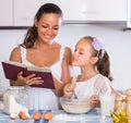 Happy girl helping mother at kitchen Royalty Free Stock Photo