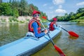 Happy girl with her brother kayaking on the river on a sunny day during summer vacation Royalty Free Stock Photo