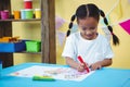 Happy girl at her desk colouring Royalty Free Stock Photo