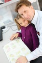 Happy girl and her father with apartment plan booklet