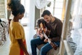 Happy father and girl are playing guitar and smiling while sitting on couch at home Royalty Free Stock Photo