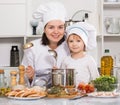 Happy girl and her mother are standing with ladle and soup together Royalty Free Stock Photo