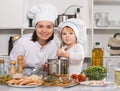 Happy girl and her mother are standing with ladle and soup together