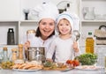 Happy girl and her mother are standing with ladle and soup together