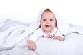 Happy Girl hiding in bed under a white blanket or coverlet. Girl at bed. Child in bed. on white background Royalty Free Stock Photo