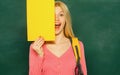 Happy girl holding announcement while stand in classroom. Student with backpack. High school education. Great