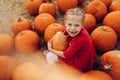 Happy girl holding a big pumpkin in her hands.