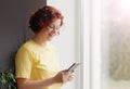 Happy girl holding cell phone using smartphone device at home. Smiling woman blogger subscribing new social media, buying in Royalty Free Stock Photo